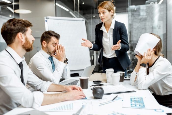 Group of people looking stressed at meeting