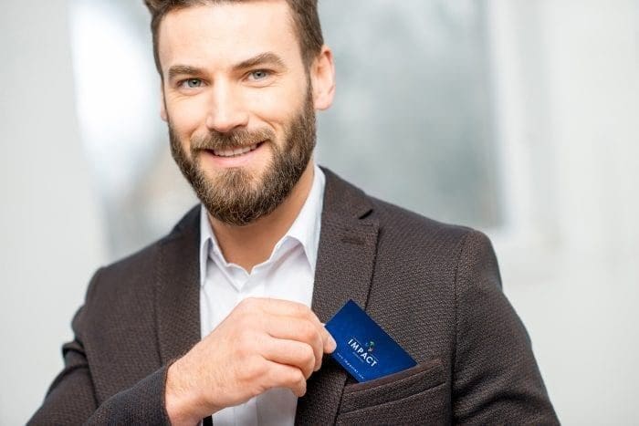 Man holding Impact Marketing business card
