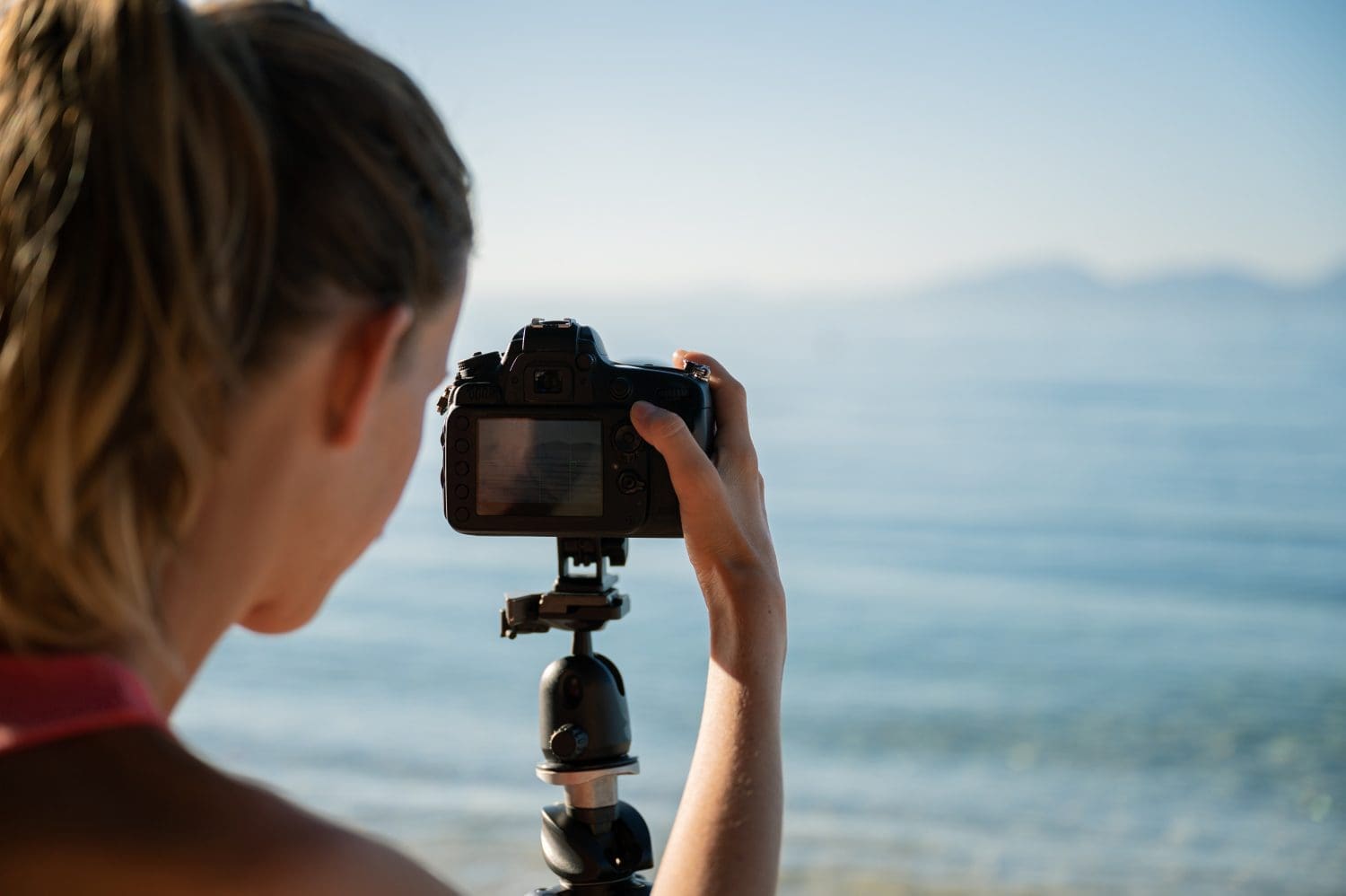 woman taking picture of ocean with camera