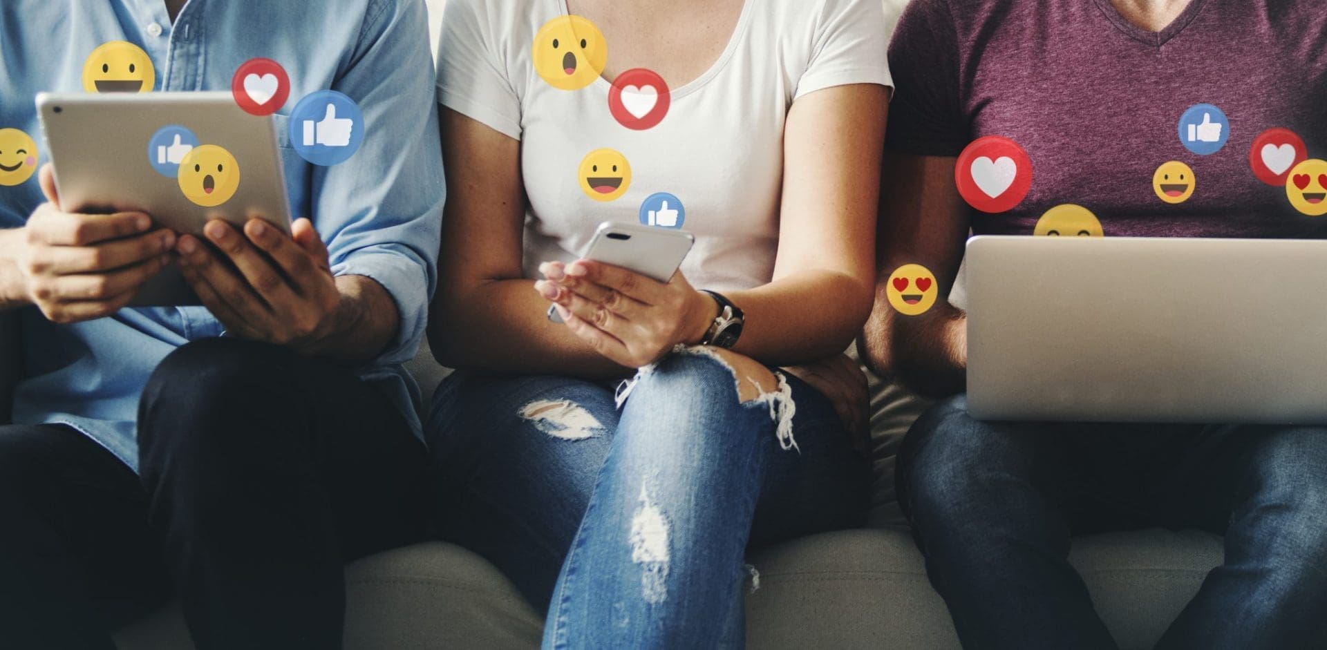 three people holding devices with social media icons